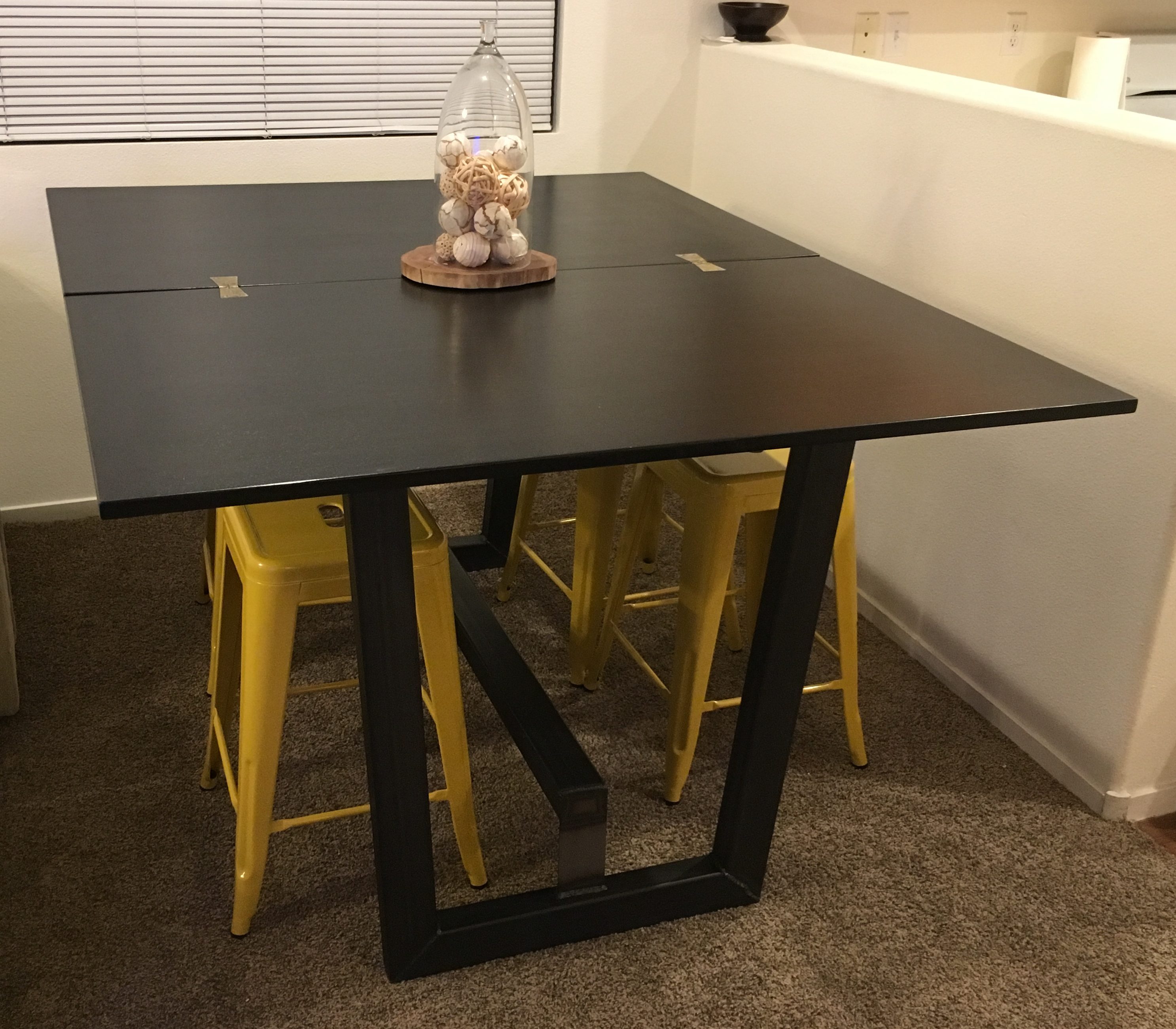 Dining table unfolded to be a larger table on a custom metal base.